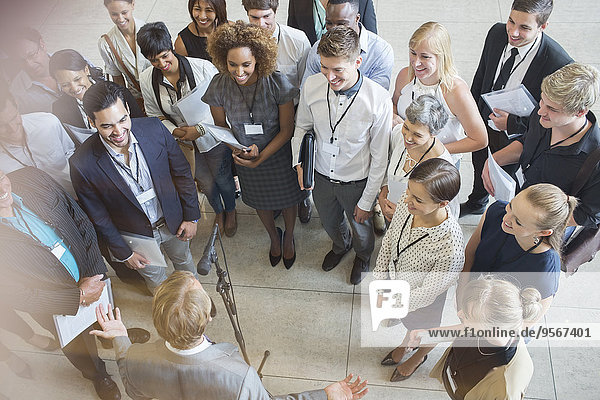 High angle view of business people looking at colleague giving speech