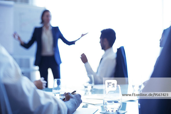 Young businesswoman standing in conference room giving presentation