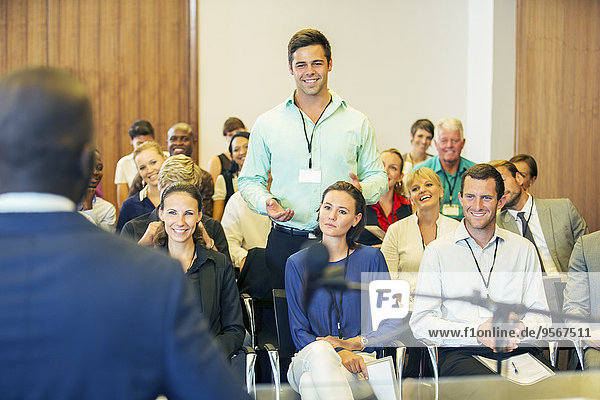 Business people attending presentation in conference room  smiling and discussing