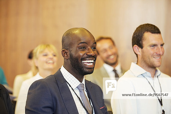 Porträt von zwei jungen Männern  einer lacht  sitzt im Konferenzraum