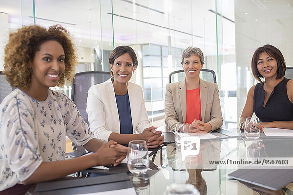 Porträt von vier fröhlichen Frauen am Konferenztisch