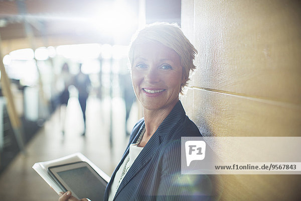 Businesswoman carrying digital tablet in office