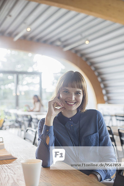 Businesswoman sitting at table in cafeteria