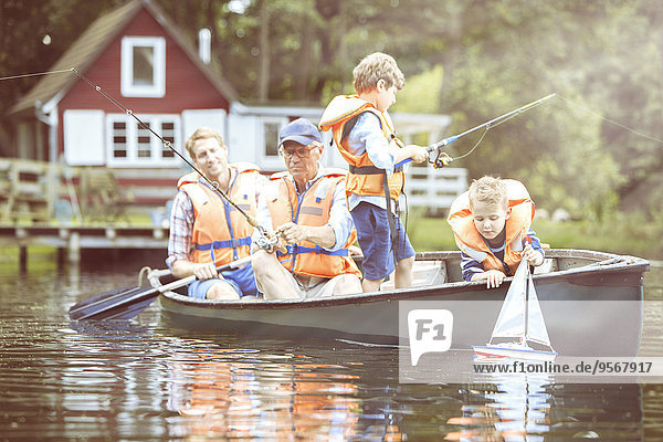 Brüder  Vater und Großvater fischen im Kanu auf dem See