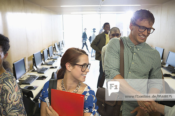 Professor greeting university students in classroom