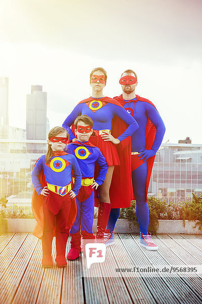 Superheldenfamilie steht auf dem Stadtdach