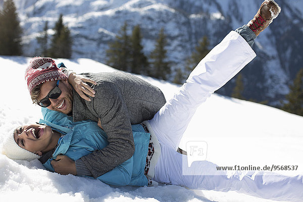 Exuberant couple laying in snow