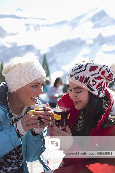 Friends in warm clothing drinking tea outdoors