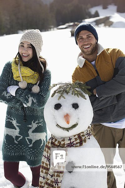 Portrait of couple with snowman