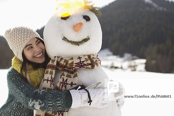Woman hugging snowman