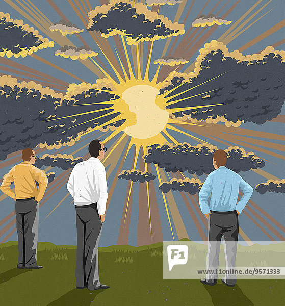 Drei Geschäftsmänner schauen auf Sonnenstrahlen hinter Regenwolken