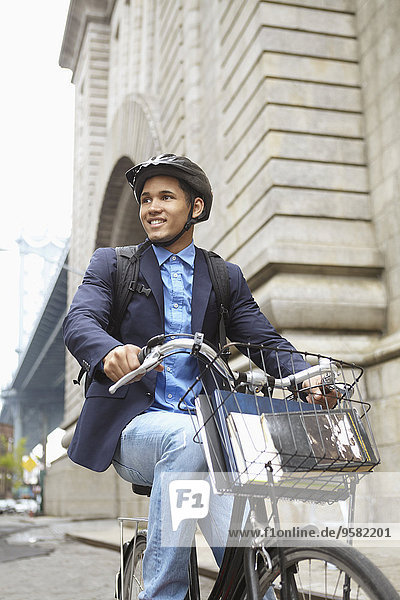 Smiling man riding bicycle on city street