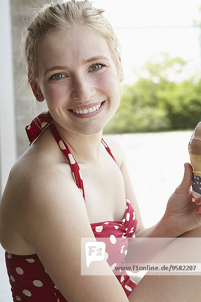 kegelförmig Kegel Frau lächeln Badeanzug Eis essen essend isst Sahne