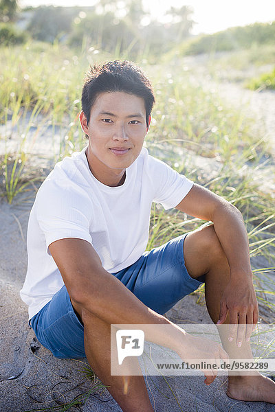 Korean man sitting on beach