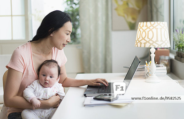 Asian mother with baby working from home
