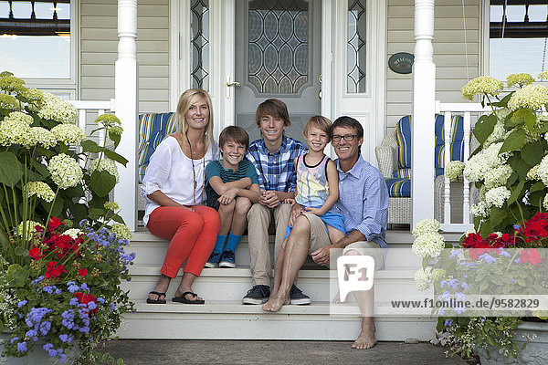 Caucasian family smiling on front porch