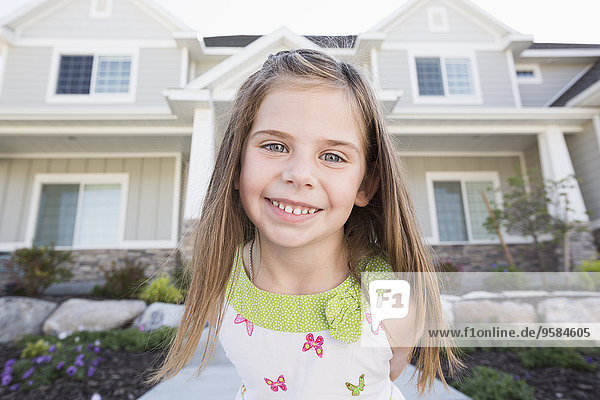 Caucasian girl smiling outside house