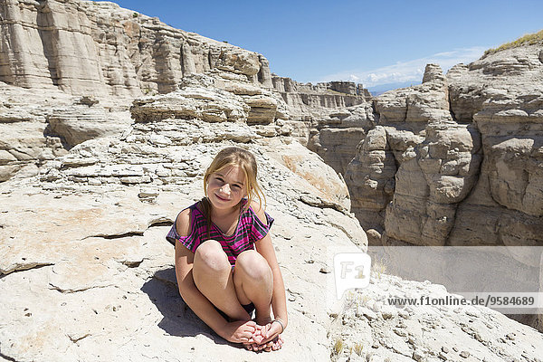 Caucasian girl sitting on rock formations