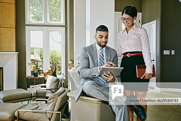 Business people using digital tablet together at home