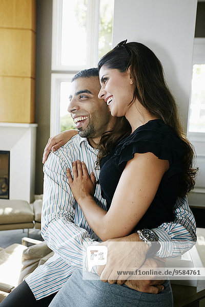 Smiling couple hugging in living room