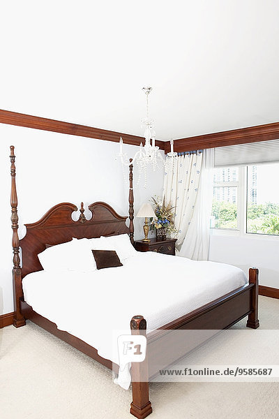 Four-poster bed and window in ornate bedroom