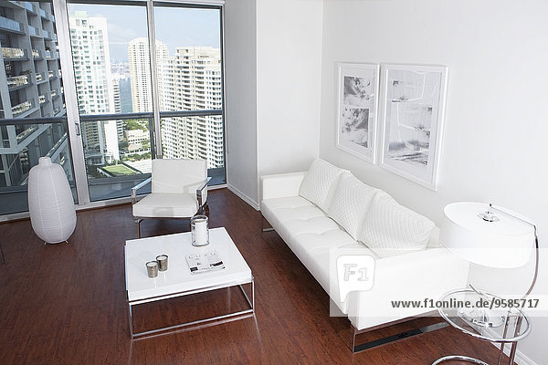 Sofa  coffee table and windows in modern apartment overlooking high rise buildings