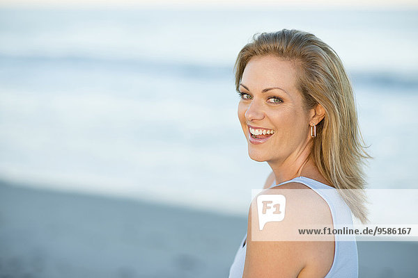Caucasian woman smiling on beach
