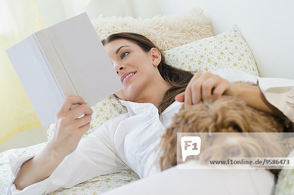 Caucasian woman reading with pet dog