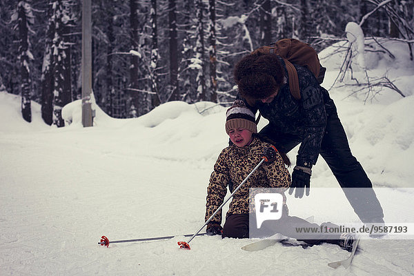 fallen fallend fällt Europäer Menschlicher Vater Hilfe Skisport Tochter querfeldein Cross Country Schnee