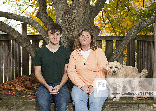 Caucasian mother  son and dog smiling in backyard