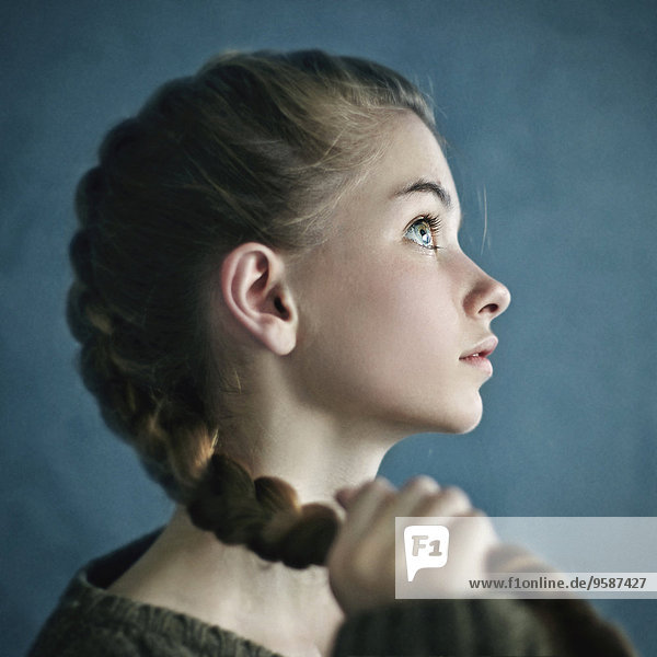 Teenage girl holding braid