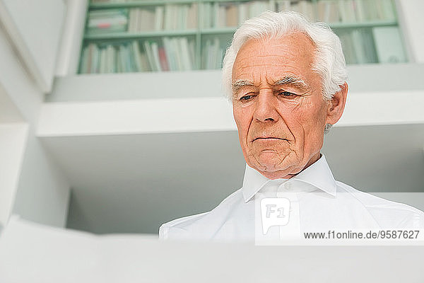 Porträt eines älteren Mannes bei der Prüfung eines Dokuments