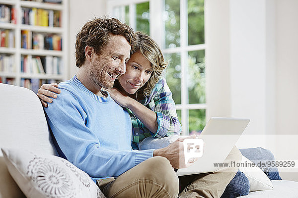Germany  Hesse  Frankfurt  Adult couple at home using laptop