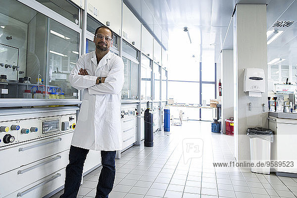 Chemiker mit gekreuzten Armen in einem Labor stehend