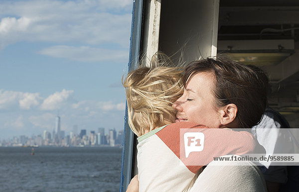 Mutter umarmt Sohn auf dem Boot