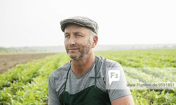 Porträt eines Bauern  der vor einem Feld steht