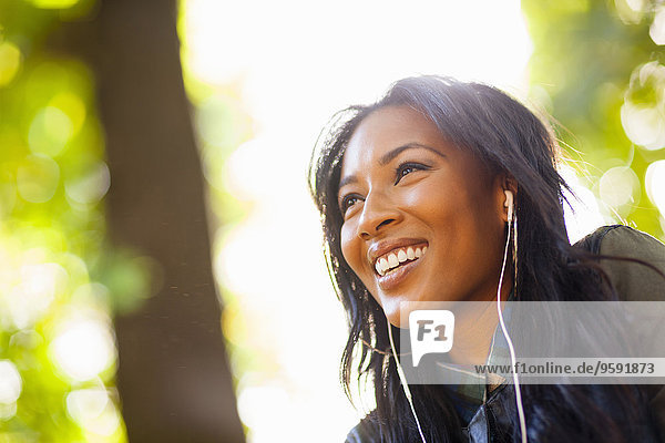 Junge Frau mit breitem Lächeln im Park