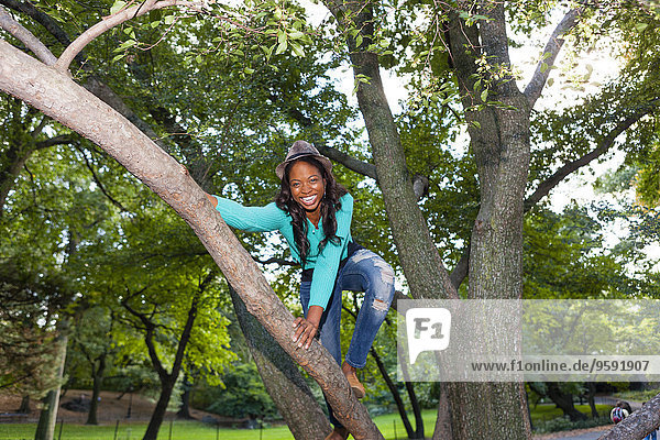 Woman climbing tree  Central Park  New York  USA