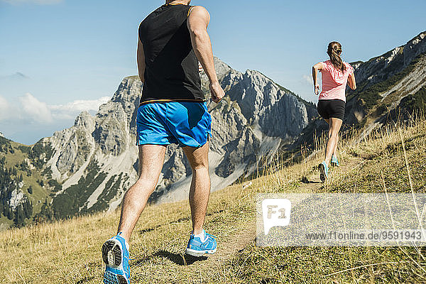 Austria  Tyrol  Tannheim Valley  young couple jogging in mountains