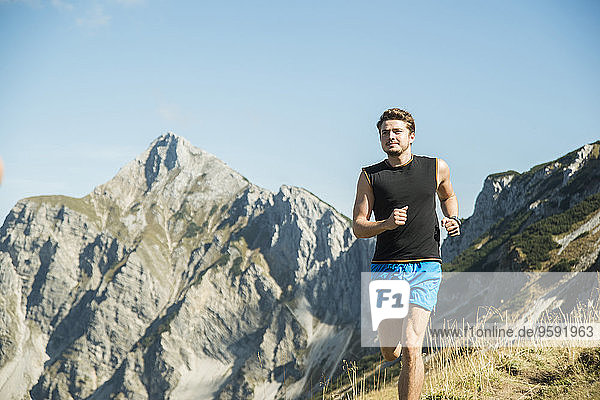 Österreich  Tirol  Tannheimer Tal  junger Mann beim Joggen in den Bergen