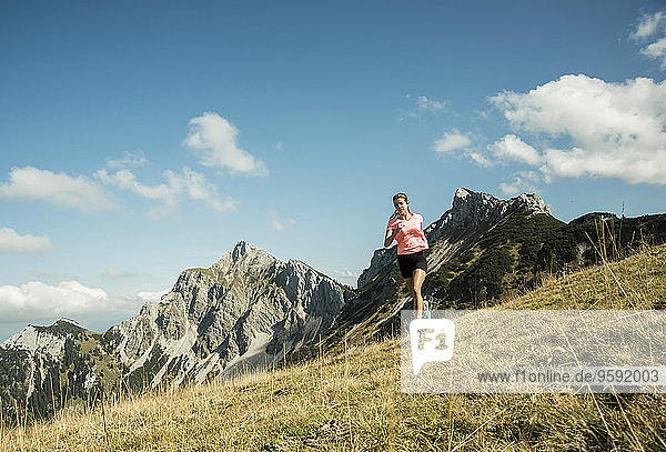 Österreich  Tirol  Tannheimer Tal  junge Frau beim Joggen im Gebirge