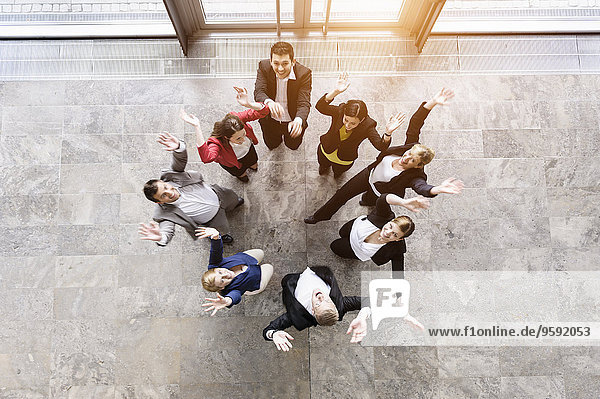 Overhead view of business team in circle jumping for joy