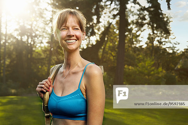 Porträt einer lächelnden Läuferin im Park