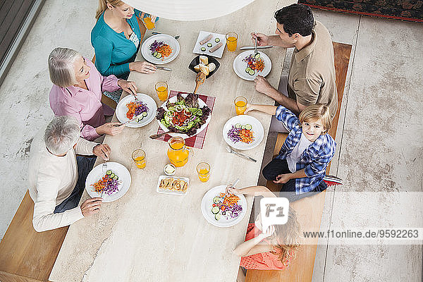 Großfamilie mit Salat und Saft am Esstisch