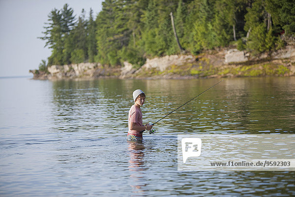 Wading teenage boy fishing in Lake Superior  Au Train Bay  Michigan  USA