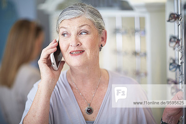 Senior woman at the optician talking on cell phone