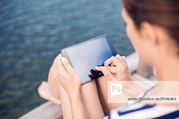 Hochwinkelansicht der reifen Frau mit digitalem Tablett am Pier