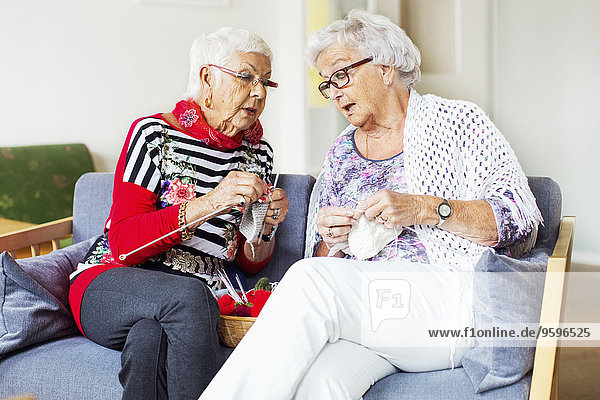 Seniorinnen diskutieren beim Stricken im Pflegeheim