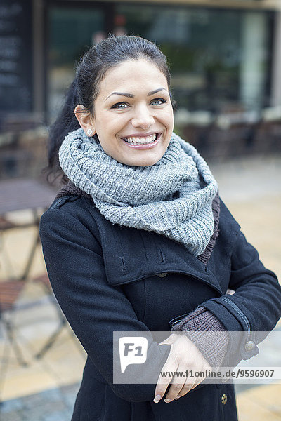 Porträt einer lächelnden mittleren erwachsenen Frau im Outdoor-Café