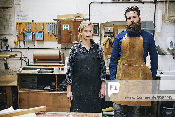 Portrait of craftsman and woman in organ workshop